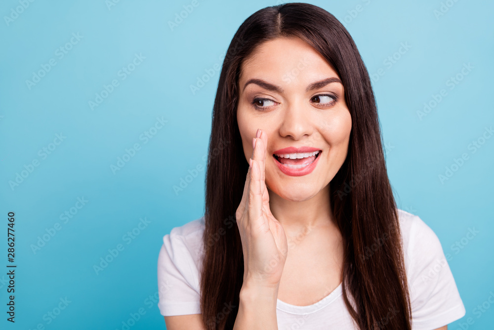 Close up photo of girl telling someone secret of her while isolated with blue background Close up photo of girl telling someone secret of her while isolated with blue background