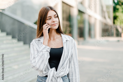 woman talks on the phone outdoors