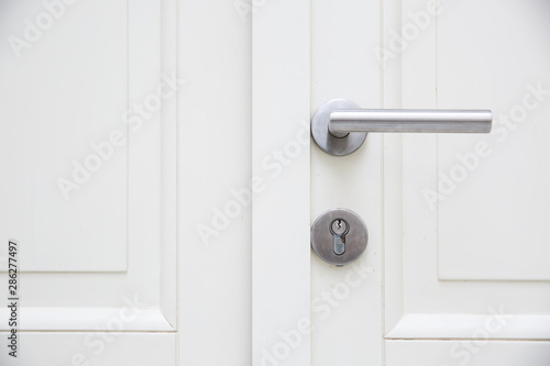 Silver aluminium modern metal handle on a white wooden door © fotosr52