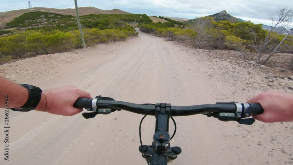 Man rides mountain bike down bumpy gravel road Man rides mountain bike down bumpy gravel road