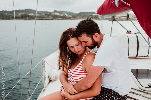Young beautiful couple enjoying a relaxing morning on a sailboat showing their love in the ocean. Travel photography. Lifestyle © lubero