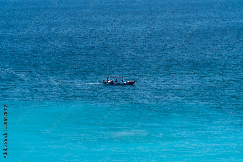 Fishing boat in the sea. Boat on the sea waves. Blue background.