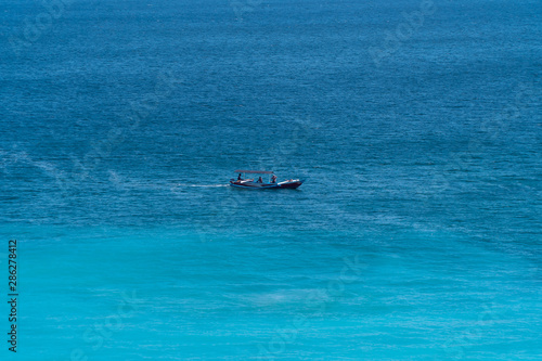 Fishing boat in the sea. Boat on the sea waves. Blue background.