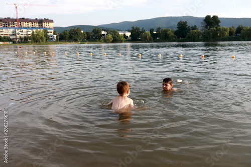 Portrait of two children swim in lake © Arkady Chubykin