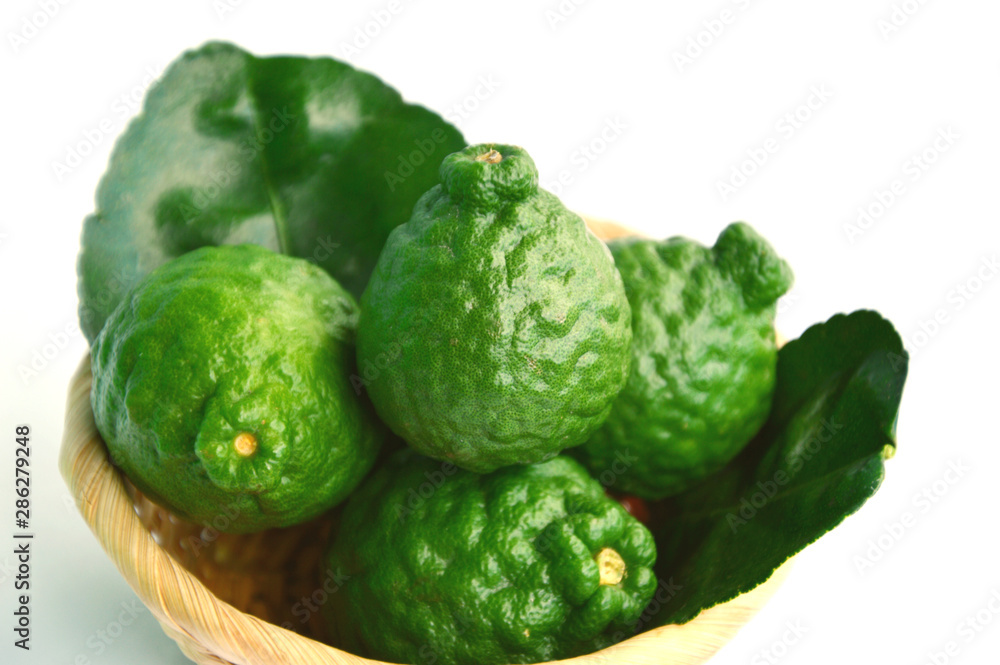 Fototapeta premium makrut lime or kaffir lime (Citrus hystrix) in basket on white background. Health Benefits of kaffir lime For Beauty and Traditional Medicine.