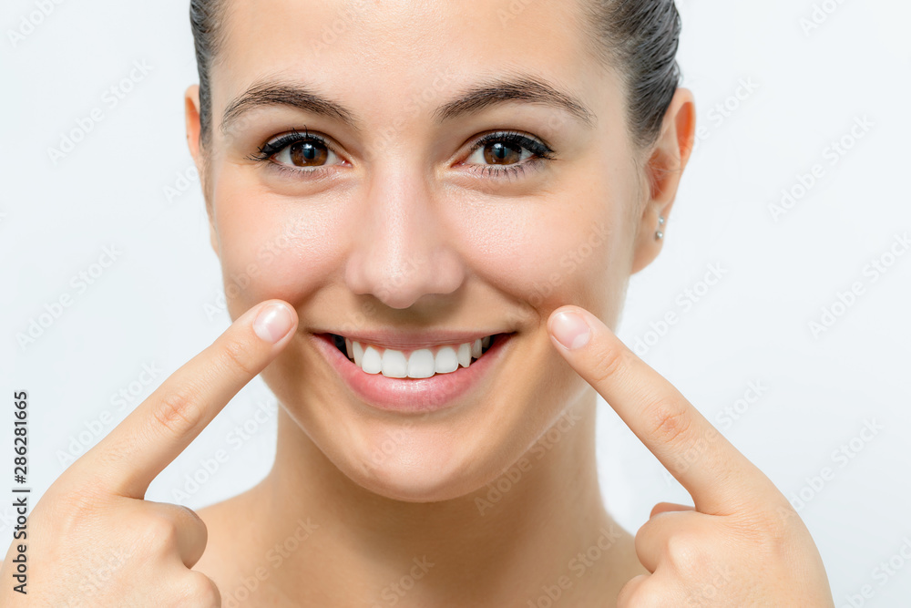 Attractive young woman showing pointing with fingers on sagging wrinkles on cheek. Attractive young woman showing pointing with fingers on sagging wrinkles on cheek.