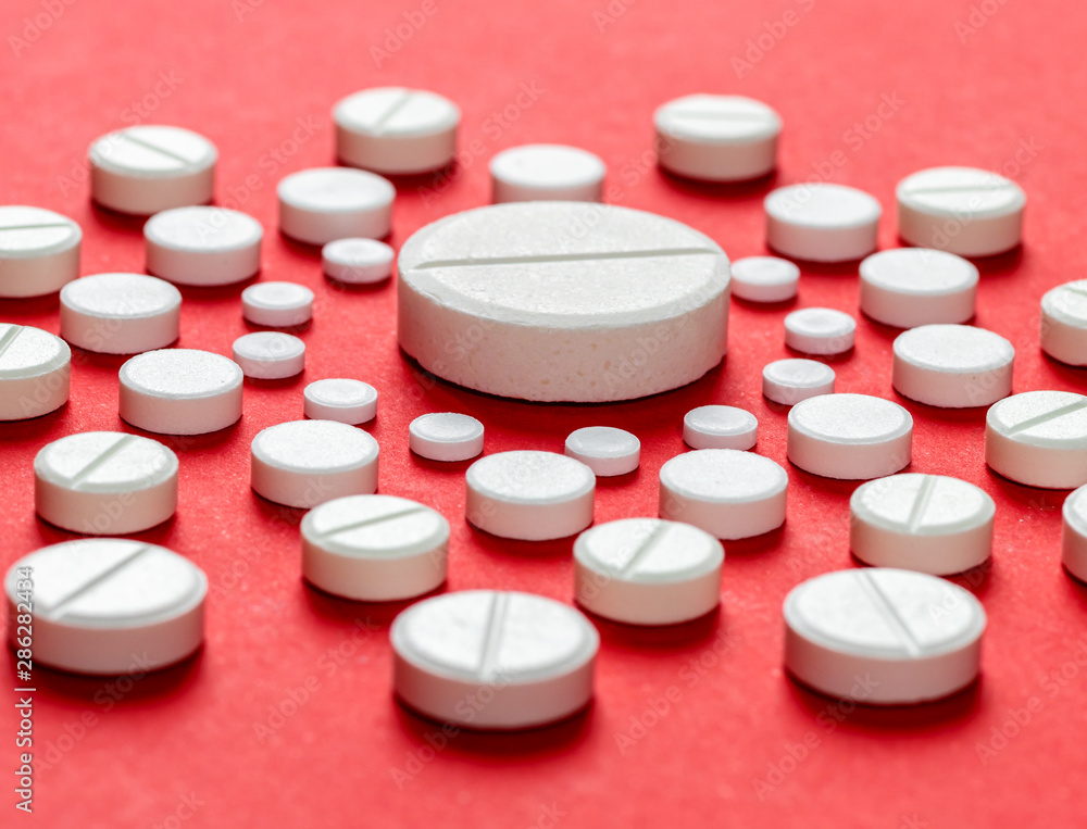 White pills on a red background White pills on a red background