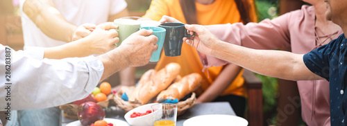 Family lunch outdoor. Married mix race couple with grand parents. White man, Asian pregnant woman with senior asian couple in tropical garden. Toasting pose. Banner frame with light leaks.