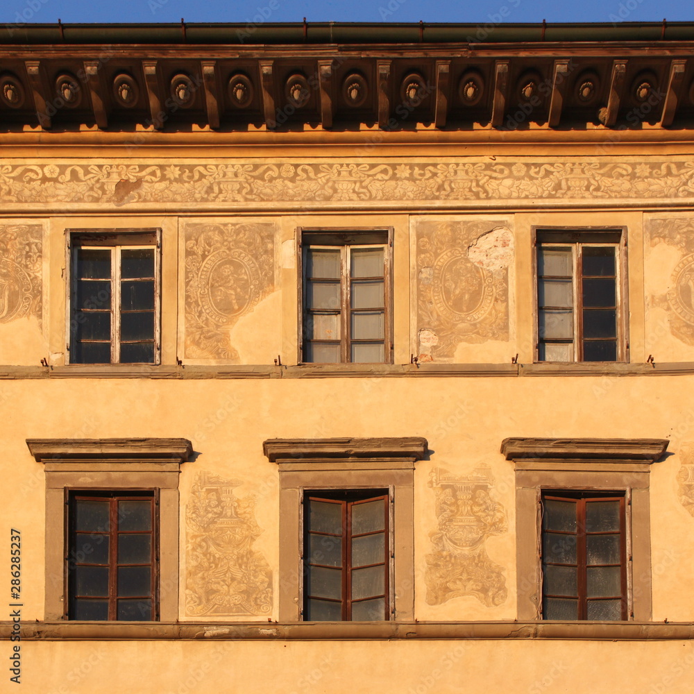 Renaissance facade with sgraffito frieze, windows and cornice at Palazzo Grassi in Pisa, Italy
