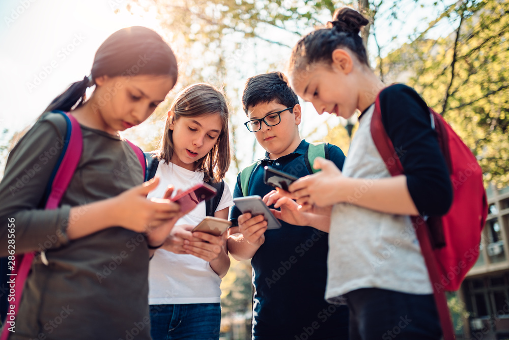 Obraz premium School kids using smart phones
