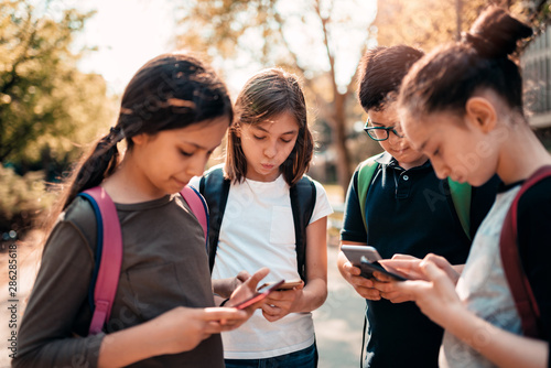 Photography School kids using smart phones in schoolyard