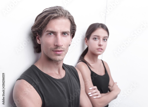 serious young couple standing near the wall © ASDF