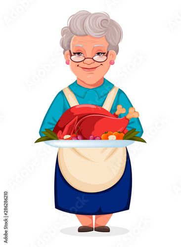 Cute grandmother holding plate with cooked turkey