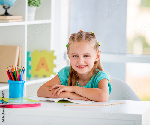 Portrait of cute little girl in school classroom