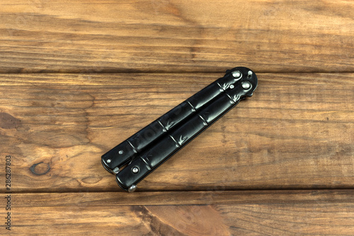 butterfly knife on a wooden background 
