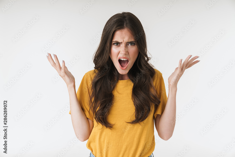 Image of angry resentful woman wearing casual t-shirt screaming and raising hands Image of angry resentful woman wearing casual t-shirt screaming and raising hands