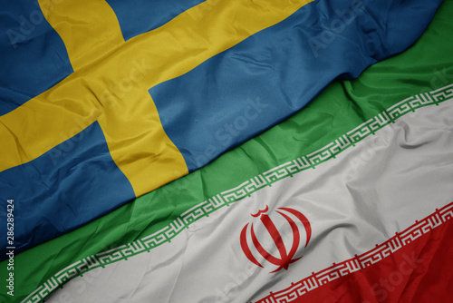 Foto waving colorful flag of iran and national flag of sweden.