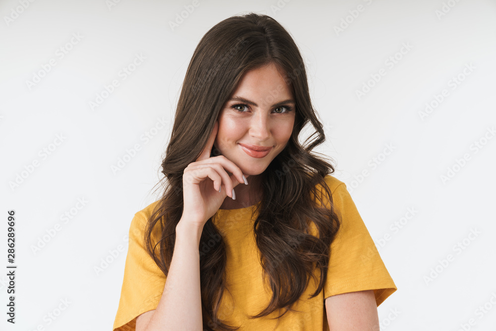Image of seductive brunette woman wearing casual t-shirt smiling and looking at camera Image of seductive brunette woman wearing casual t-shirt smiling and looking at camera