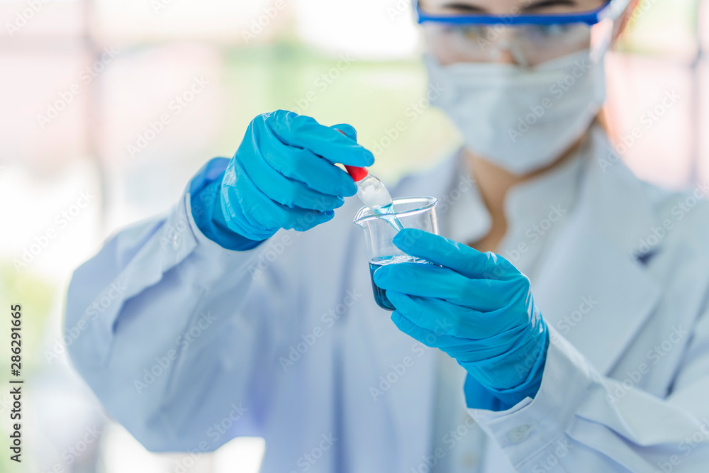 A young beautiful asian woman scientist dropping blue liquid substance in science tube with chemistry experiment in hospital lab. Portrait of science & healthcare concept. Soft and clean filter. A young beautiful asian woman scientist dropping blue liquid substance in science tube with chemistry experiment in hospital lab. Portrait of science & healthcare concept. Soft and clean filter.