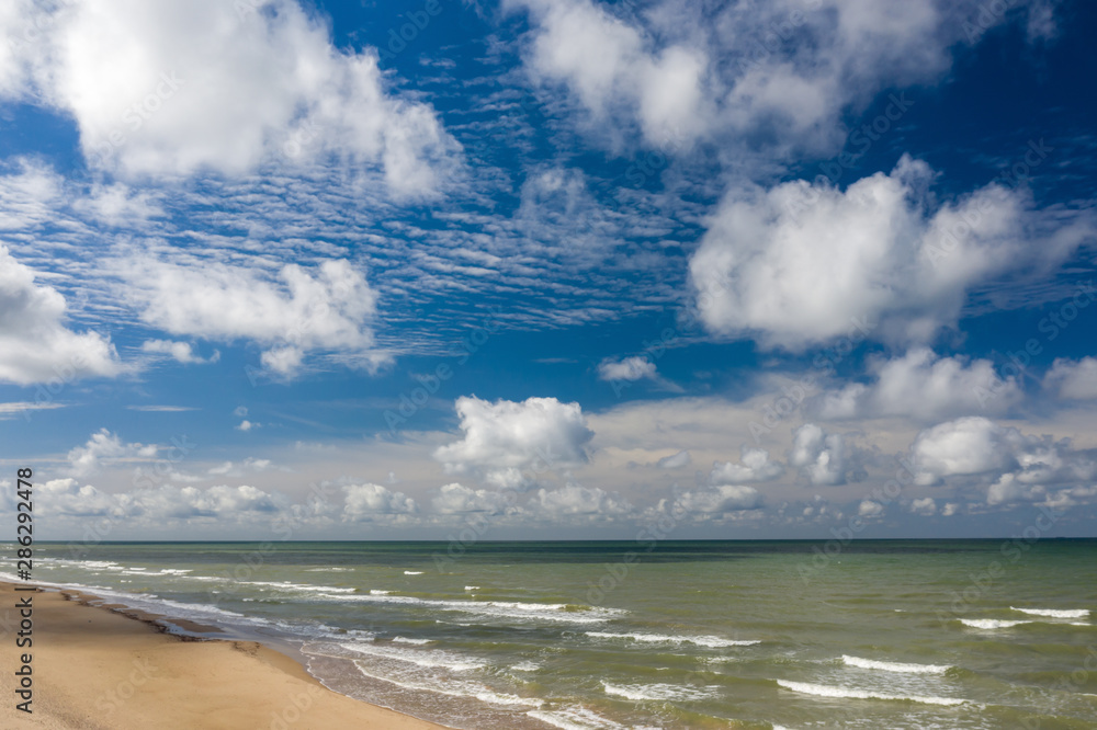 View of the sea. Empty seaside. Blue sky. Cloudy weather.