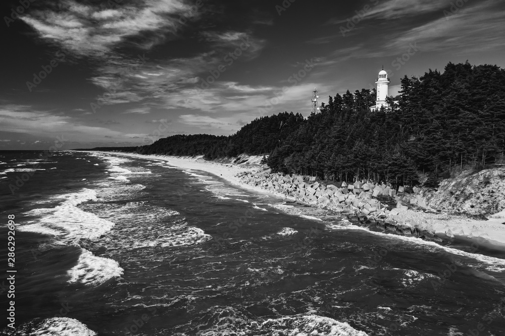 The view of the sea and the Uzhava lighthouse. Black and white.
