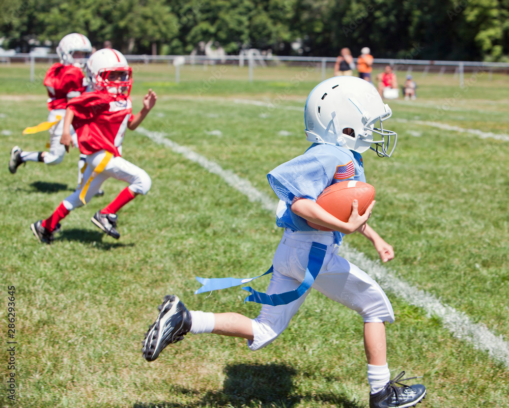 Unidentifiable kids playing flag American football Unidentifiable kids playing flag American football