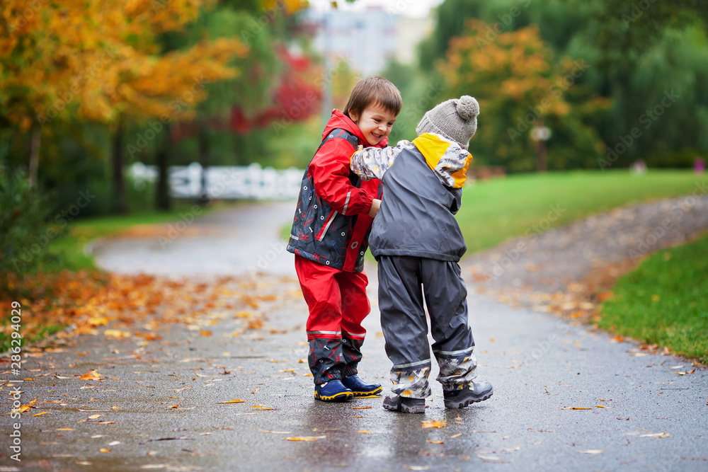 Two children, fighting over toy in the park on a rainy day Two children, fighting over toy in the park on a rainy day