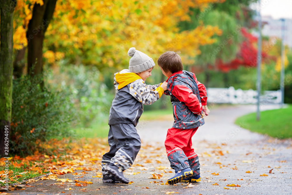 Two children, fighting over toy in the park on a rainy day Two children, fighting over toy in the park on a rainy day