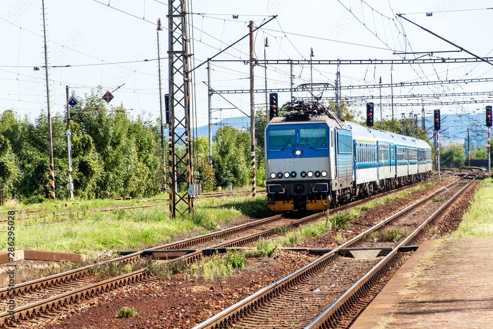 Train on platform in station in Czech Republic. Railroad tracks with concrete sleepers. Local railway station. Train on platform in station in Czech Republic. Railroad tracks with concrete sleepers. Local railway station.