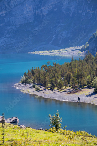 The panorama in summer view over the Oeschinensee (Oeschinen lake) and the alps on the other side near Kandersteg on bernese oberland in Switzerland. photo