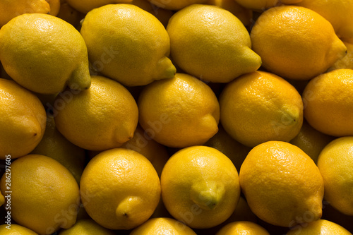 A pile of lemons at the vegetable market. Macro background of citruses.
