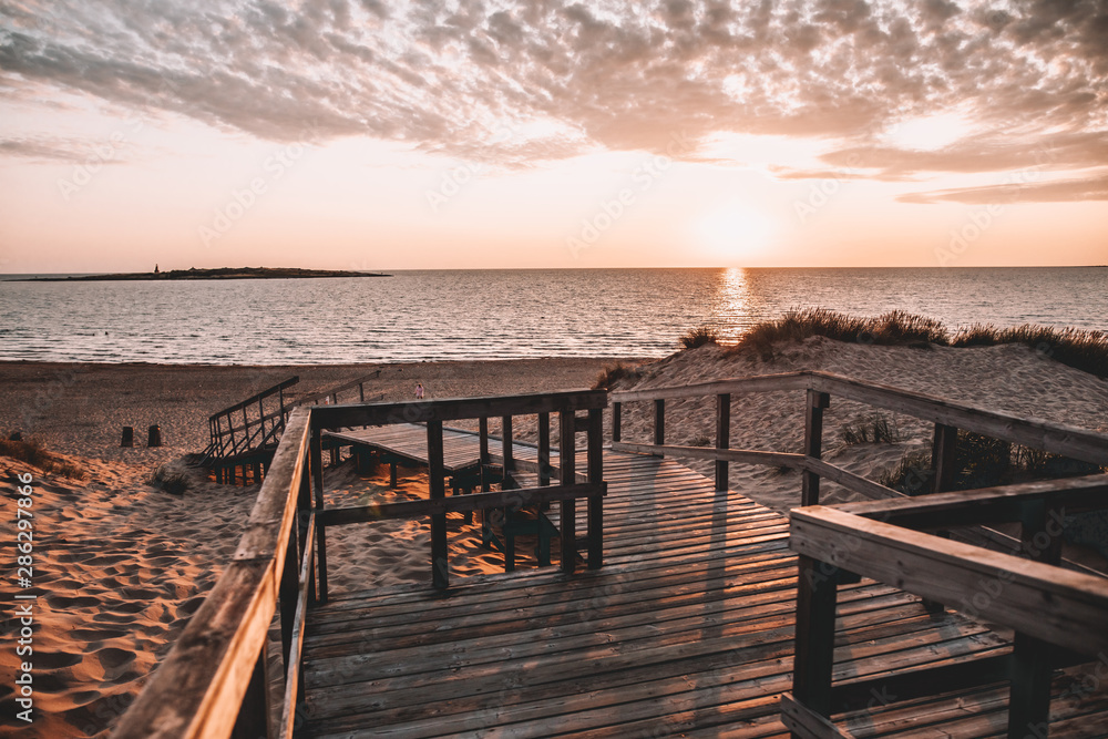 Obraz premium Tree deck on Swedish beach during sunset