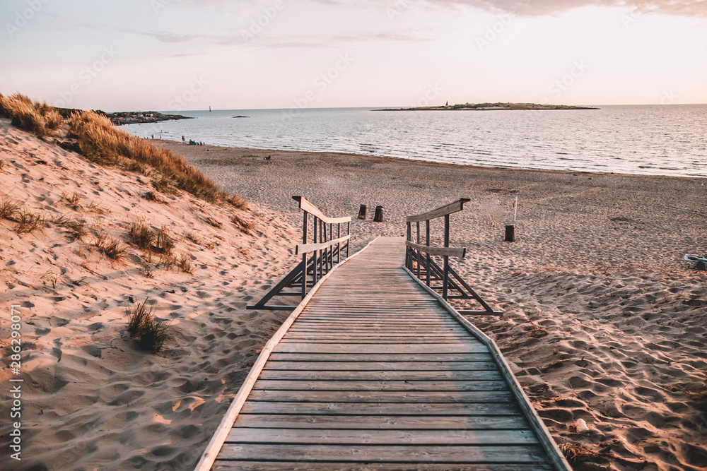 Tree deck on Swedish beach during sunset