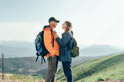 Man and woman in a relationship together outside in a mountain landscape. Joint walk in the mountains. Loving married couple.