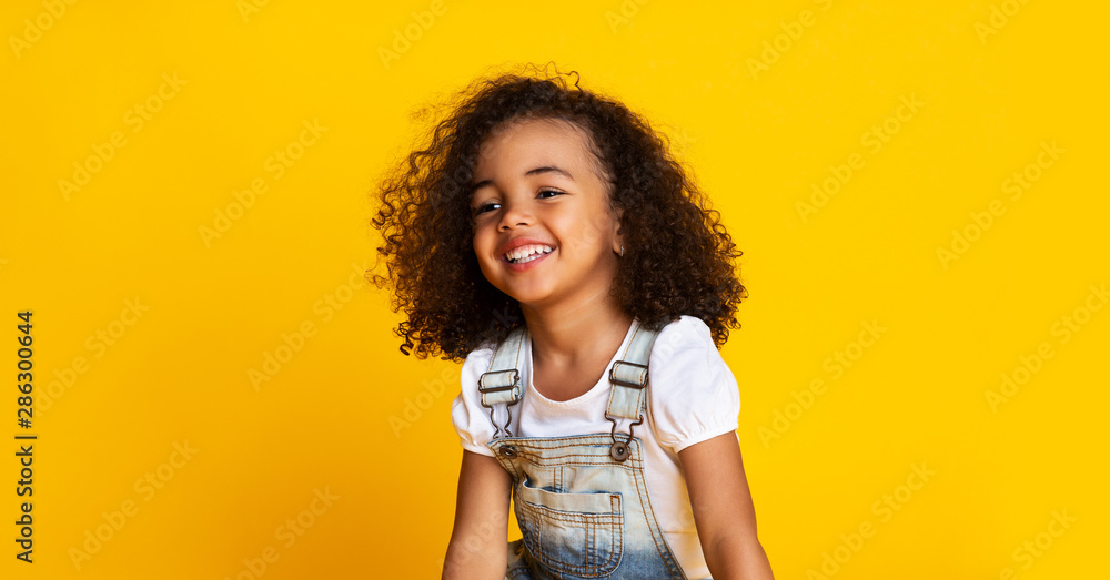 Laughing cute afro girl portrait, yellow background - obrazy, fototapety, plakaty 