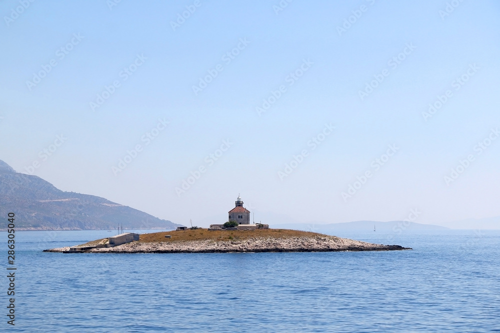 Picturesque lighthouse on a small island near town Hvar, on island Hvar, Croatia. Picturesque lighthouse on a small island near town Hvar, on island Hvar, Croatia.