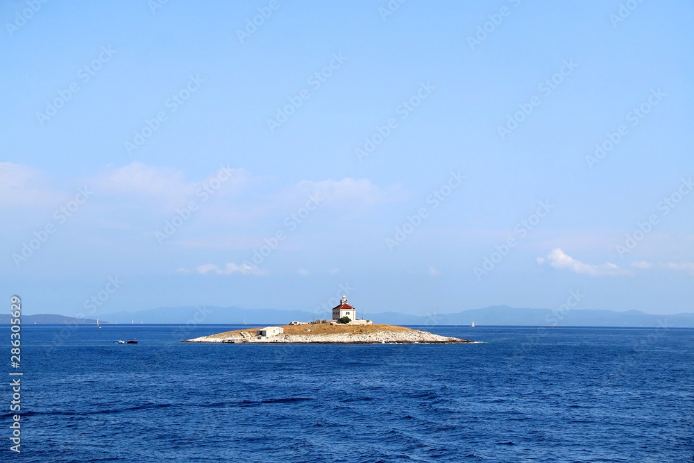 Picturesque lighthouse on a small island near town Hvar, on island Hvar, Croatia. Picturesque lighthouse on a small island near town Hvar, on island Hvar, Croatia.