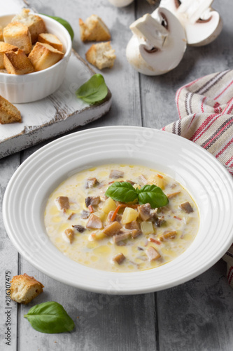 Cheese soup with mushrooms, potatoes, carrots and croutons Delicious cozy first course, autumn food