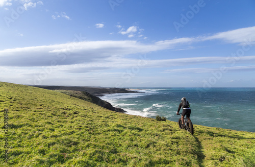 Man cycling on coastal cliff top trail