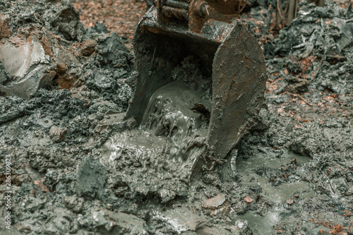 Working excavator bucket in liquid dirt