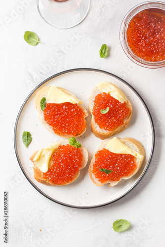 Red caviar on baguette toast with butter, appetizer for wine, champagne. Holiday, new year, Christmas, buffet. Delicious canape, food