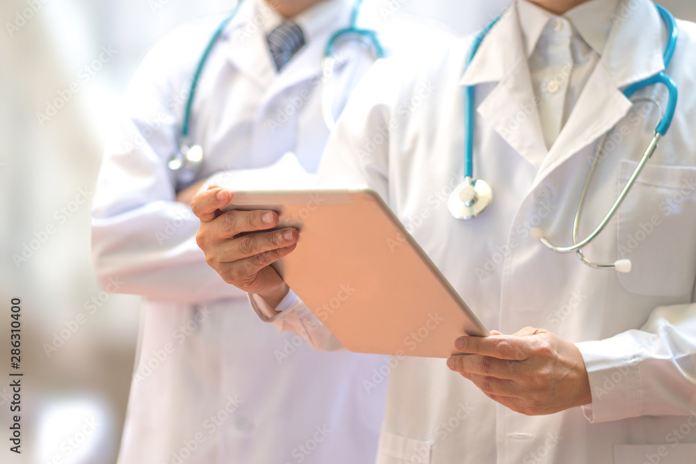 Medical doctor or physician team in white gown uniform with stethoscope and tablet computer in hospital or clinic, Healthcare technology cocept. Medical doctor or physician team in white gown uniform with stethoscope and tablet computer in hospital or clinic, Healthcare technology cocept.