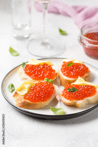 Red caviar on baguette toast with butter, appetizer for wine, champagne. Holiday, new year, Christmas, buffet. Delicious canape, food