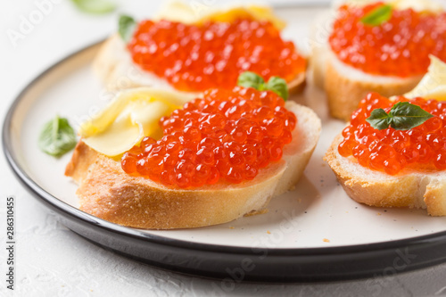 Red caviar on baguette toast with butter, appetizer for wine, champagne. Holiday, new year, Christmas, buffet. Delicious canape, food