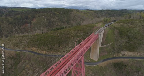 Train approaching and crossing Garabit bridge photo