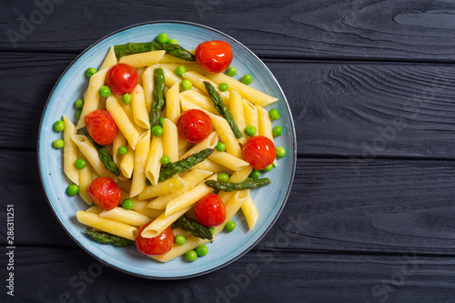 Penne pasta salad with asparagus , tomatoes and peas