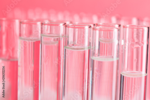 Close up laboratory test tubes on red background
