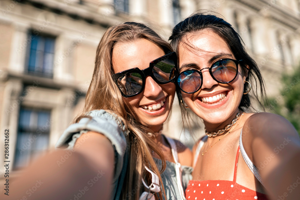 Happy young women in sunglasses taking selfie