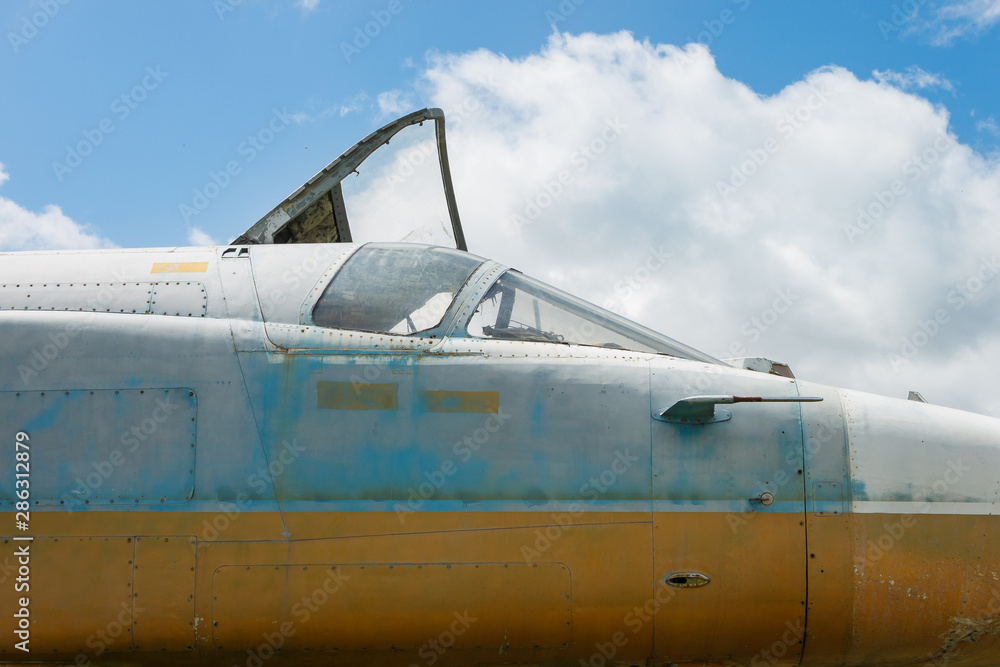 Fuselage and cockpit of an old jet fighter on sky background. Fragment