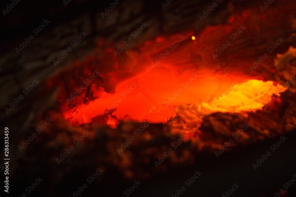Fototapeta premium Burning coal closeup. Abstract background red hot burning fire in the oven macro close up of coal. Shallow depth of field (DOF)
